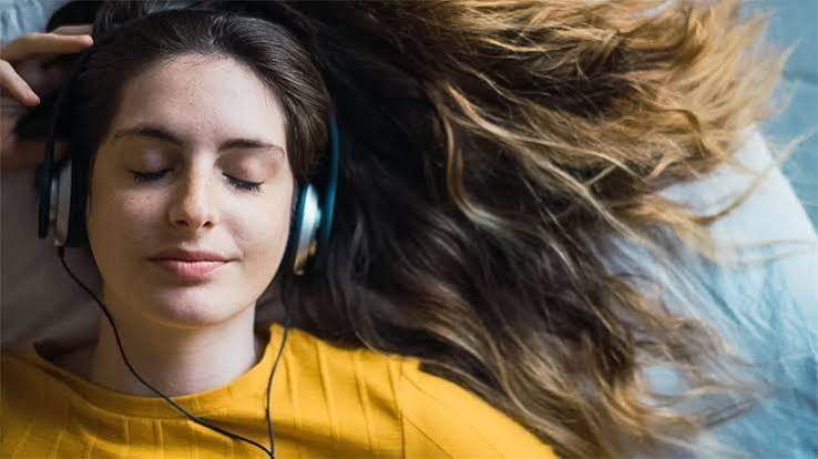 Donna con gli occhi chiusi che ascolta musica in cuffia